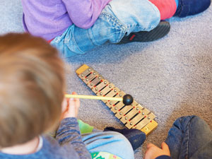 Ein Kind macht Musik auf einem Xylophon